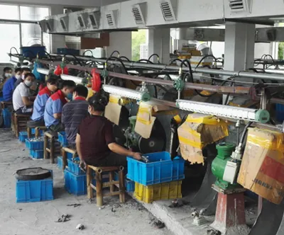 Row of workers hand polishing coffin handle castings at the Virtue Hardware factory